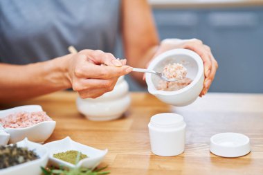 Güzel, sağlıklı kadın evde doğal kozmetik ürünleri hazırlıyor.