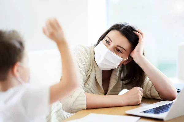 Niño y madre exhausta tratando de trabajar en casa durante la pandemia de coronavirus —  Fotos de Stock