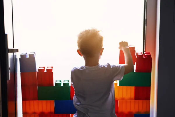 Egy kisfiú falat épít az otthoni karanténban a koronavírus világjárvány idején. — Stock Fotó