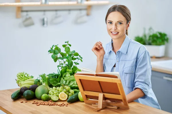 Gesunde erwachsene Frau mit grünem Essen in der Küche — Stockfoto