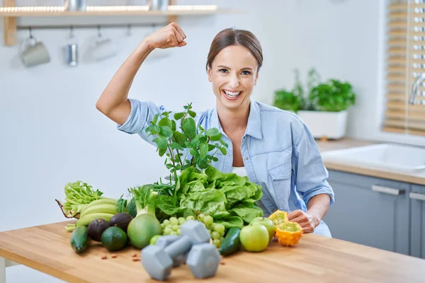 キッチンで緑の食べ物を持つ健康的な大人の女性 — ストック写真