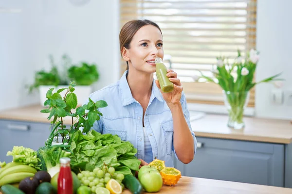 Mujer adulta saludable con comida verde en la cocina —  Fotos de Stock