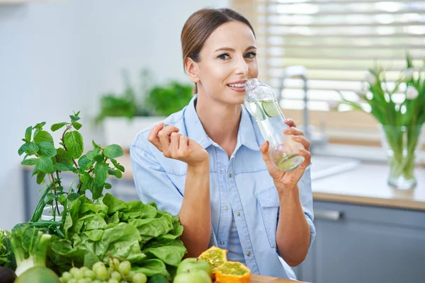 Mutfakta yeşil yemekleri olan sağlıklı yetişkin bir kadın. — Stok fotoğraf