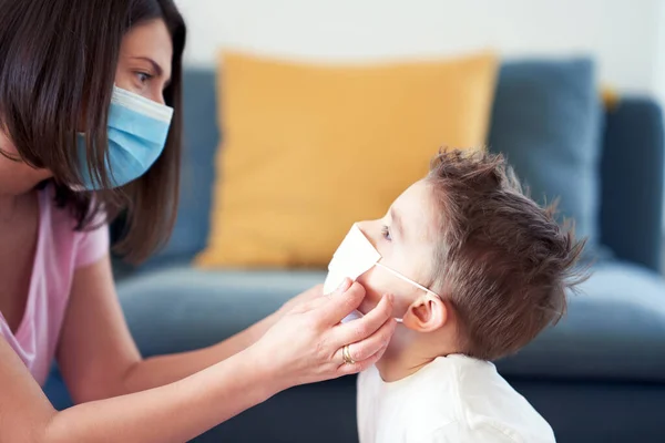 Mutter und Kind setzen bei Coronavirus-Pandemie Schutzmasken auf — Stockfoto
