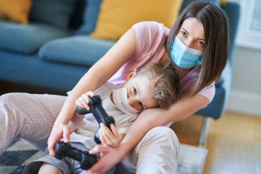 Anne ve çocuk, koronavirüs salgını sırasında evde birlikte oynuyorlar.