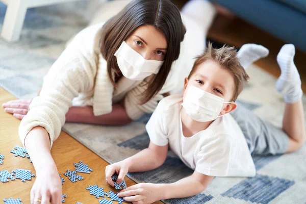 Madre e hijo jugando juntos en el aislamiento del hogar durante la pandemia de coronavirus —  Fotos de Stock