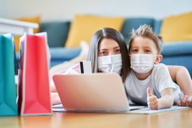 Anne ve çocuk koronavirüs salgını sırasında online alışveriş yapıyorlar.