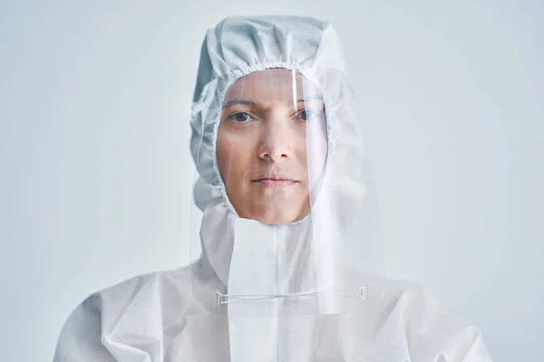 Mulher de traje de risco biológico e escudo facial sobre fundo branco . — Fotografia de Stock