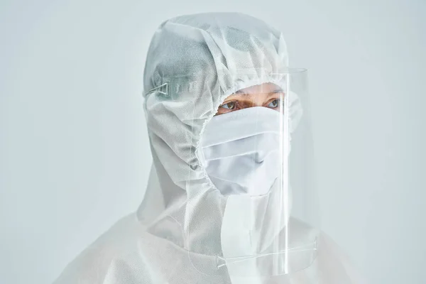 Woman in bio-hazard suit and face shield on white background. — Stock Photo, Image