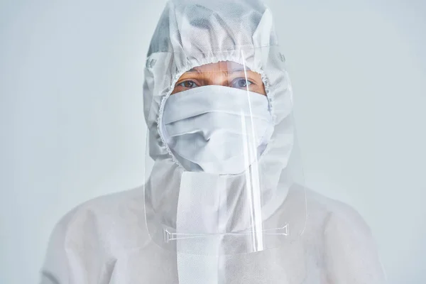 Woman in bio-hazard suit and face shield on white background. — Stock Photo, Image