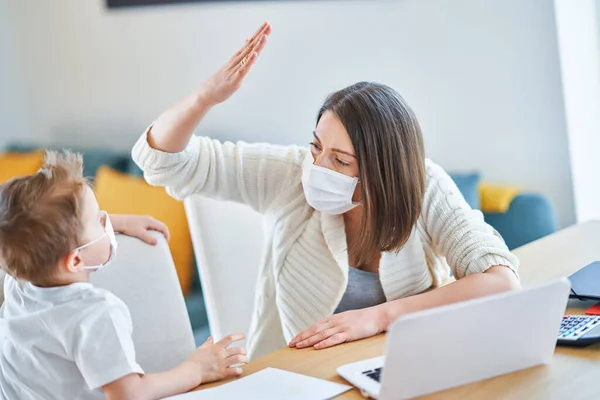 Junge und erschöpfte Mutter versuchen während der Coronavirus-Pandemie zu Hause zu arbeiten — Stockfoto