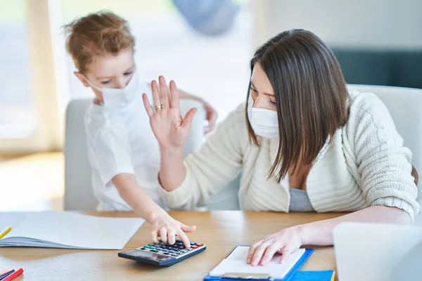 Boy and exhausted mother trying to work at home during coronavirus pandemic — Stock Photo, Image