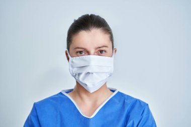 Koruyucu maske takan kadın doktor ya da hemşirenin yakın portresi