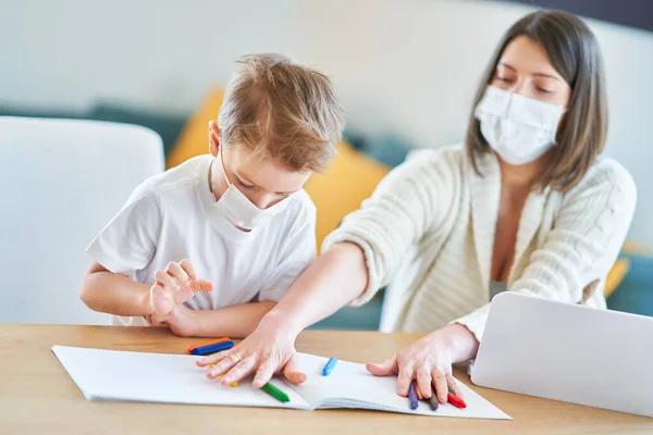 Jongen en uitgeputte moeder probeert thuis te werken tijdens een coronavirus pandemie — Stockfoto