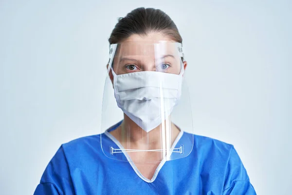 Retrato de médico feminino usando máscara protetora e protetor facial — Fotografia de Stock