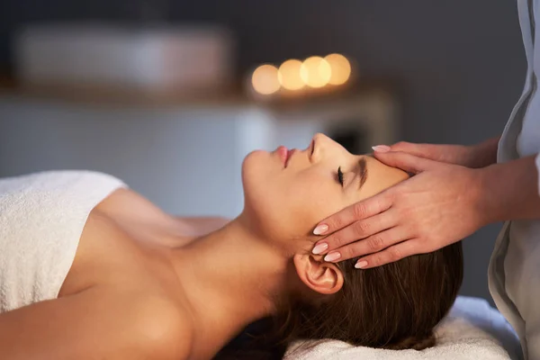 Relaxed woman receiving head massage