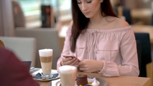 Pareja joven citas en restaurante y el uso de teléfonos inteligentes — Vídeo de stock