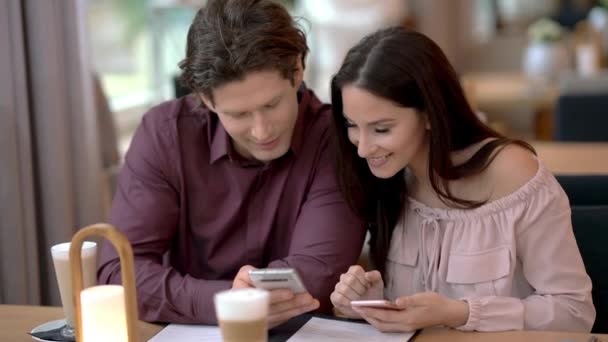 Jeune couple sortir ensemble dans le restaurant et en utilisant des smartphones — Video