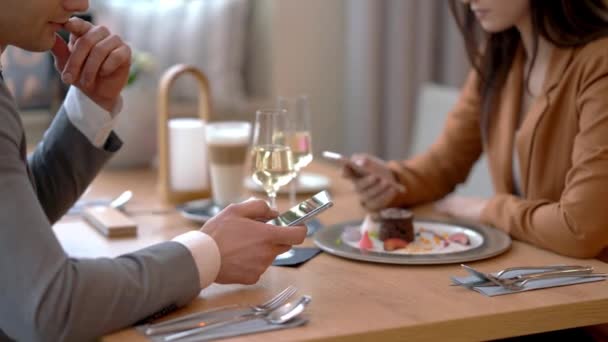 Unga par dejtar i restaurang och använder smartphones — Stockvideo