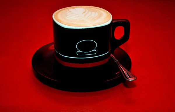 Una hermosa taza de café sobre un fondo marrón claro — Foto de Stock