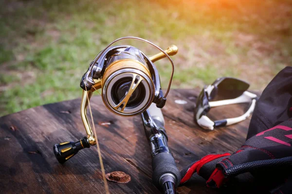 Spinning rod and reel on wooden table — Stock Photo, Image