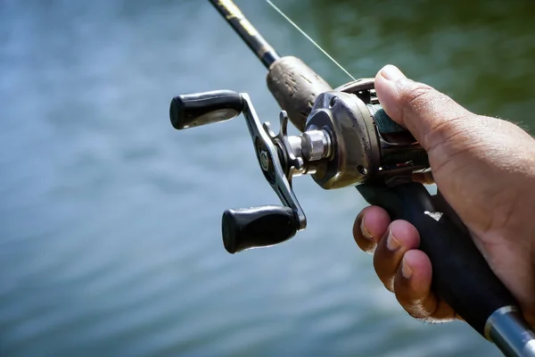 Baitcasting reel in the fisherman hand — Stock Photo, Image