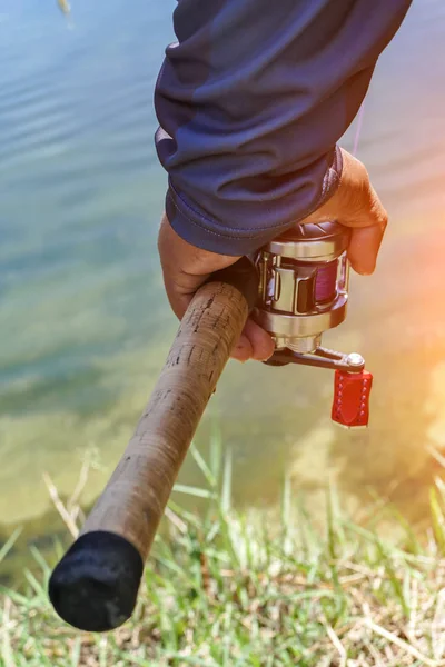 Рыболовецкая катушка в руке рыбака — стоковое фото
