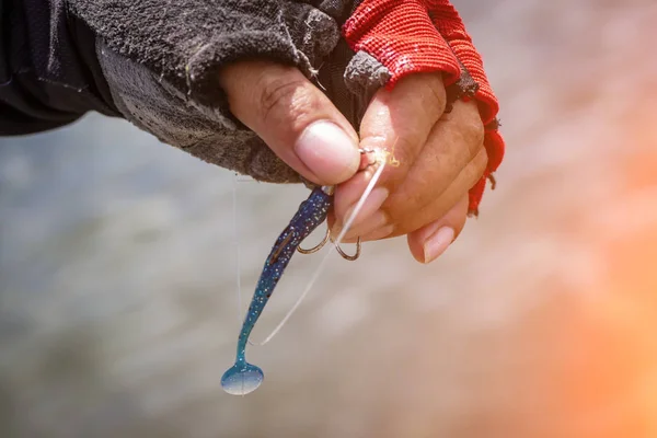 Angler tying a fishing hook to rubber worm lure — Stock Photo, Image