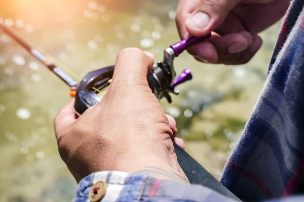 Carrete de baitcasting en la mano del pescador — Foto de Stock