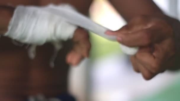 Boxeador tailandés se prepara para el entrenamiento envolviendo su mano con calico — Vídeo de stock