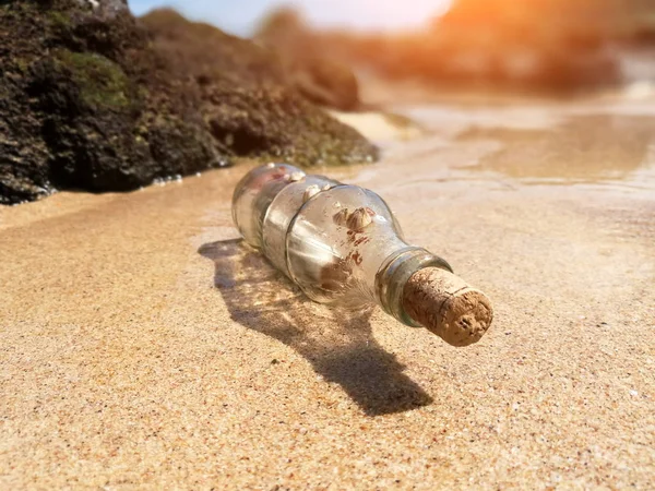 Пляшка і повідомлення на березі моря — стокове фото