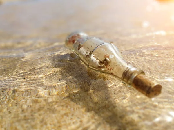 Bottle and a message on seashore — Stock Photo, Image