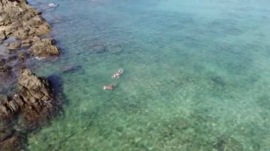 İnsansız hava aracı, açık denizde şnorkelle yüzen iki turisti kuş bakışı yakalıyor..