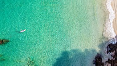 Andaman Denizi 'nin berrak sularında kürek çeken turistler ayağa kalkıyor.