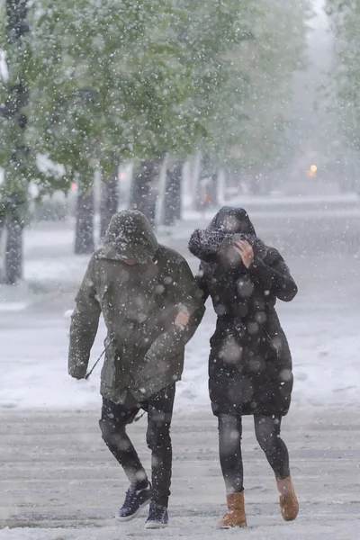 Le persone vanno con difficoltà in tempesta di neve nel mese di aprile . — Foto Stock