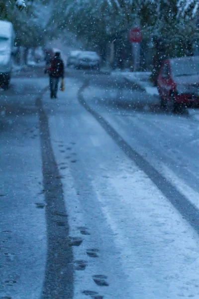 Man walking between Traces of car wheels in Snow Storm nel mese di aprile . — Foto Stock