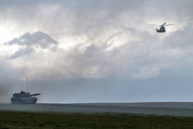 havada uçan askeri helikopter uçağı, sahada tank 