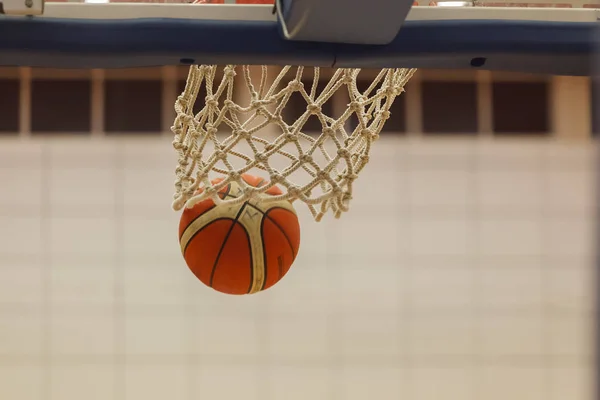 motion photo of basketball ball in air at basketball net