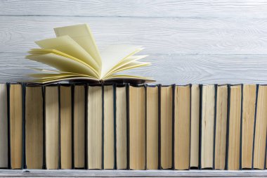 Açık kitap, ahşap masadaki ciltli kitaplar. Okula dönelim. Boşluğu kopyala