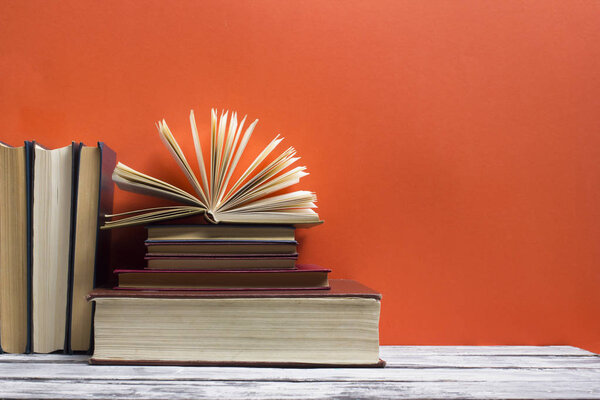 Открытая книга, книги в твердом переплете на деревянном столе. Возвращайся в школу. Копирование пространства