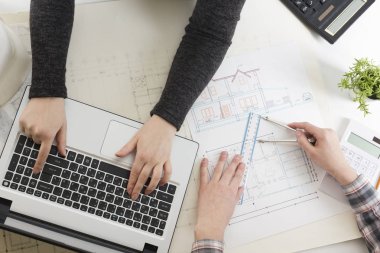Mimarlar Blueprint, gayrimenkul projesi üzerinde çalışıyor. Mimar işyeri - mimari proje, planları, cetvel, hesap makinesi, laptop ve bölücü pusula. İnşaat kavramı. Mühendislik araçları.