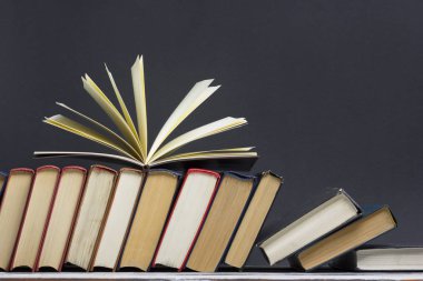 Açık kitap, ahşap masadaki ciltli kitaplar. Okula dönelim. Boşluğu kopyala