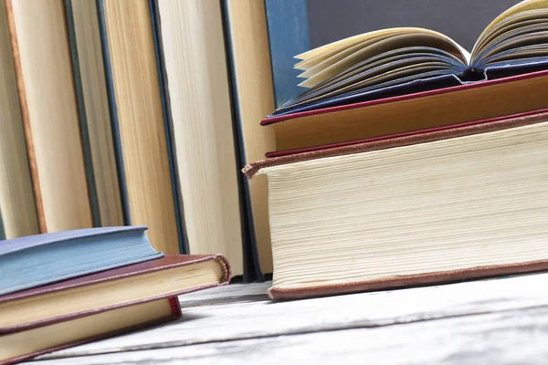 Açık kitap, ahşap masadaki ciltli kitaplar. Okula dönelim. Boşluğu kopyala