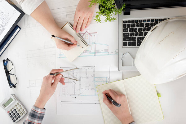 Architects working on blueprint, real estate project. Architect workplace - architectural project, blueprints, ruler, calculator, laptop and divider compass. Construction concept. Engineering tools.