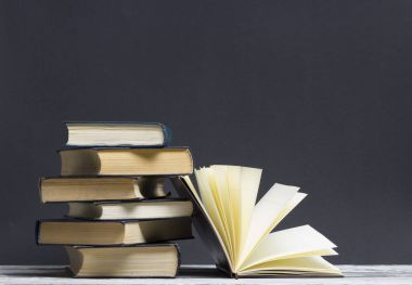 Açık kitap, ahşap masadaki ciltli kitaplar. Okula dönelim. Boşluğu kopyala