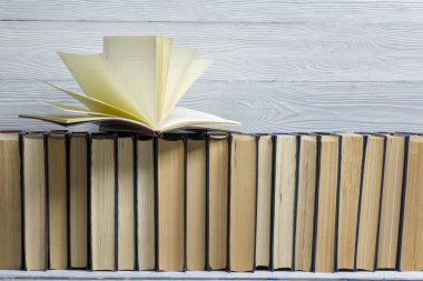 Açık kitap, ahşap masadaki ciltli kitaplar. Okula dönelim. Boşluğu kopyala