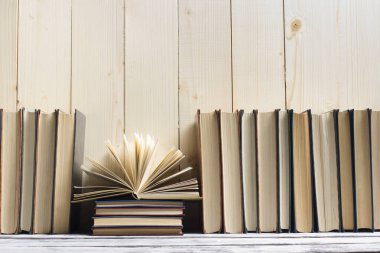 Açık kitap, ahşap masadaki ciltli kitaplar. Okula dönelim. Boşluğu kopyala