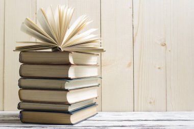 Açık kitap, ahşap masadaki ciltli kitaplar. Okula dönelim. Boşluğu kopyala