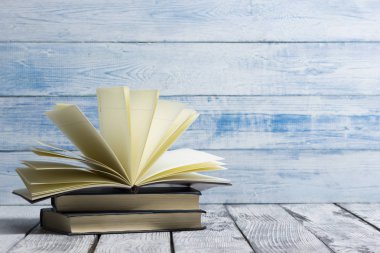 Açık kitap, ahşap masadaki ciltli kitaplar. Okula dönelim. Boşluğu kopyala