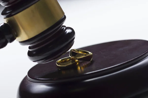 이혼 개념입니다. 결혼 반지와 판사 망치의 클로즈업 — 스톡 사진